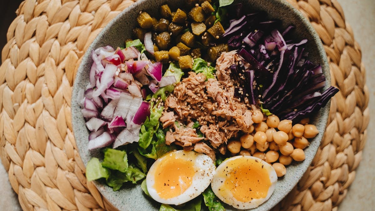 Delicious salad bowl with tuna, eggs, and fresh vegetables, perfect for a nutritious meal.